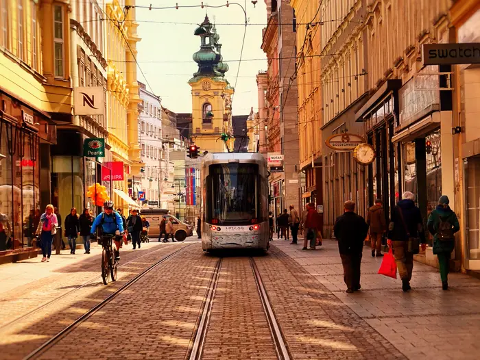A street in Linz with a tram, cyclists and pedestrians.